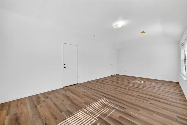 a view of empty room with wooden floor