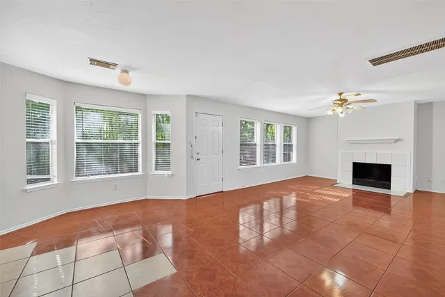 a view of an empty room with a fireplace and a window