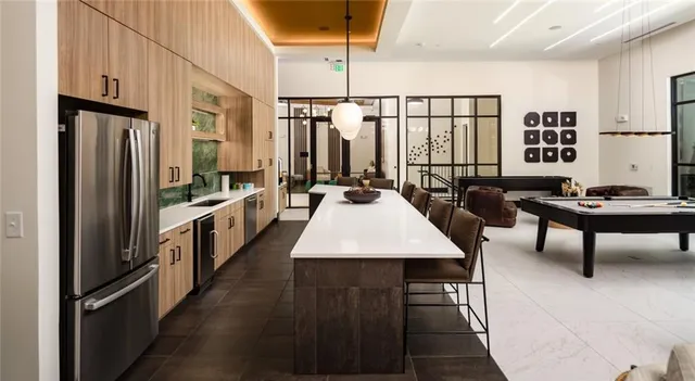 a dining hall with couches a flat tv screen and a dining table with garden view