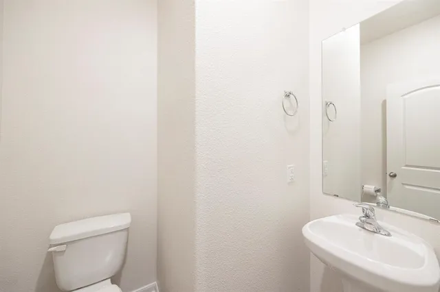 a bathroom with a toilet a sink and mirror