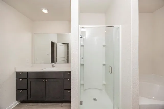 a bathroom with a granite countertop sink a mirror and shower