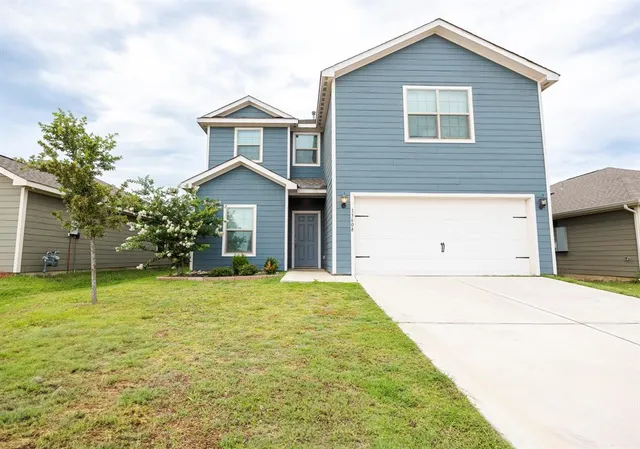 a front view of a house with a yard and garage