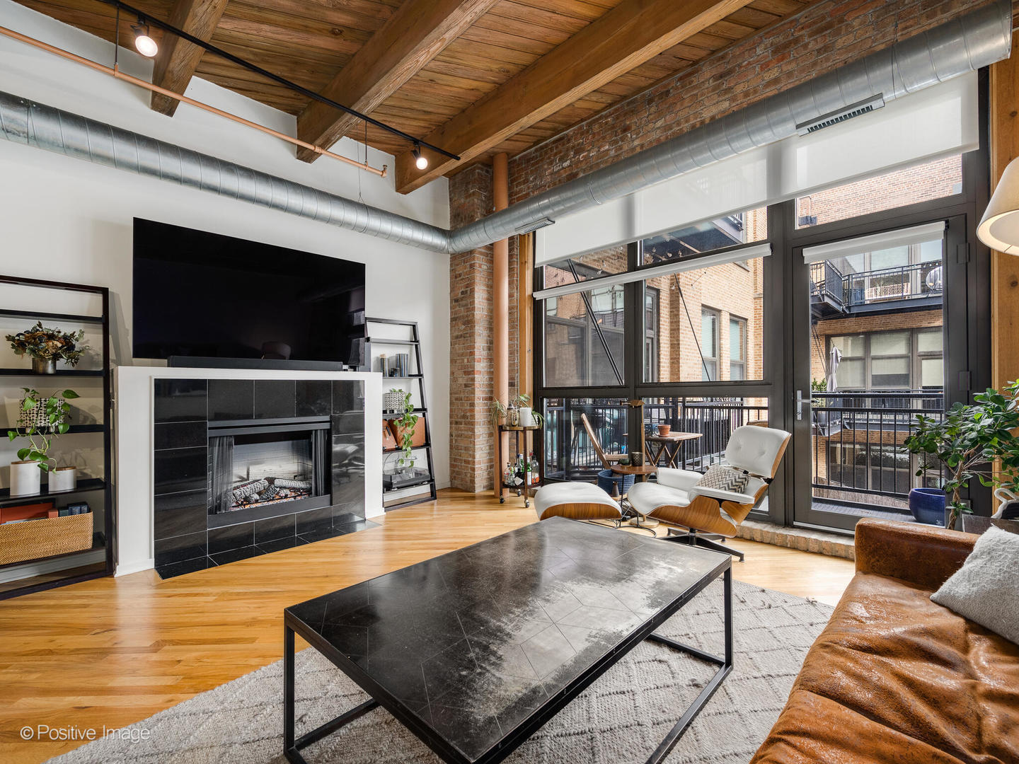 1040 West Adams Street, Unit 350 Chicago, IL 60607 - Photo 4 of 22 a living room with furniture a flat screen tv and a fireplace