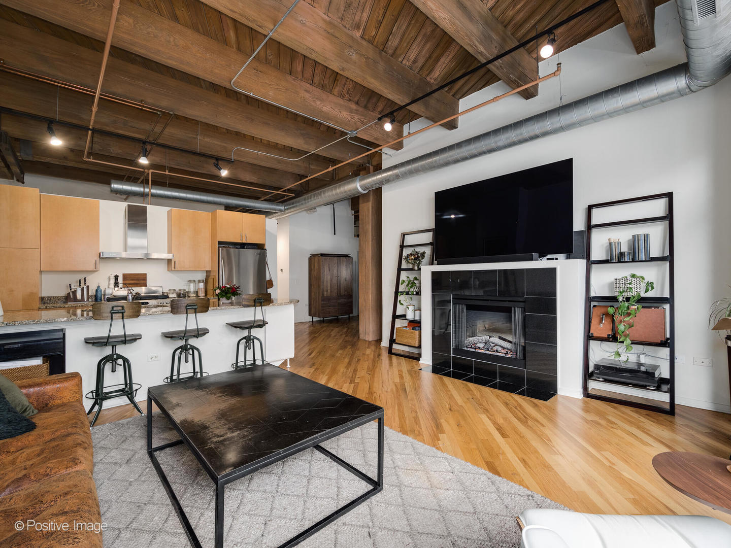 1040 West Adams Street, Unit 350 Chicago, IL 60607 - Photo 6 of 22 a living room with furniture a flat screen tv and a fireplace
