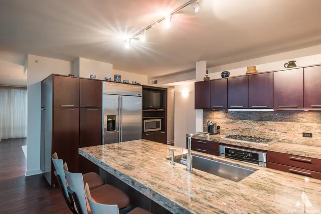 a kitchen with stainless steel appliances granite countertop a refrigerator and a stove top oven