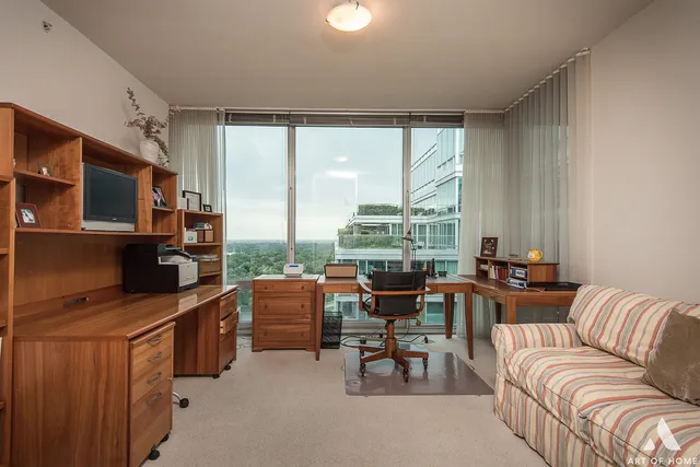 a living room with furniture a flat screen tv and large windows