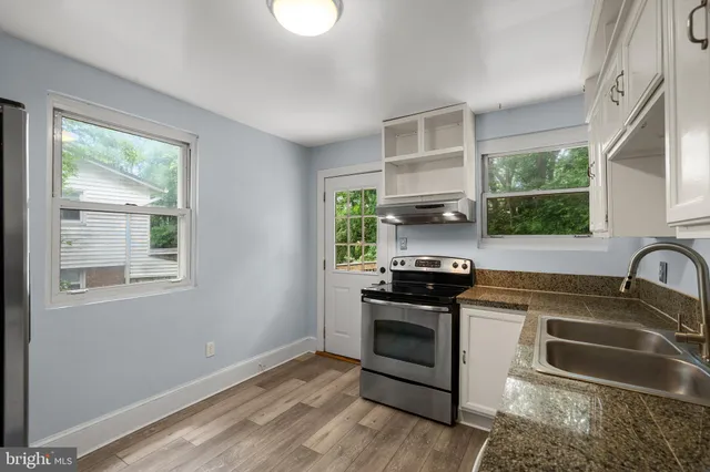 a kitchen with granite countertop a stove sink and window