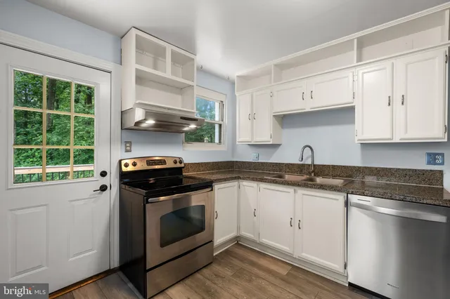 a kitchen with stainless steel appliances granite countertop a sink and a stove