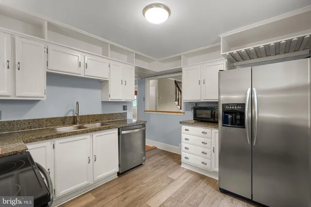 a kitchen with stainless steel appliances a refrigerator sink and cabinets