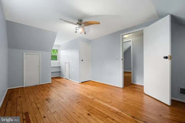a view of a big room with wooden floor and windows