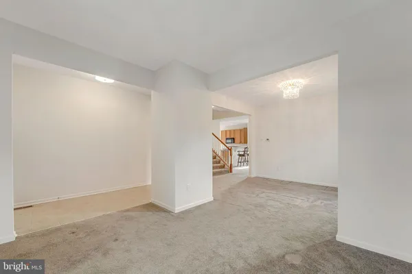 an empty room with kitchen view and closet