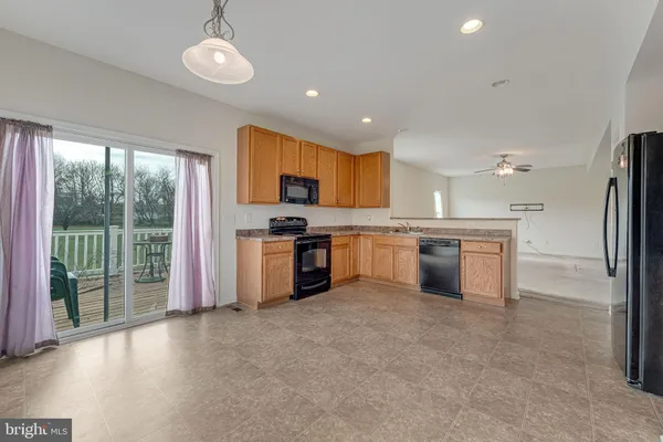 a kitchen with stainless steel appliances granite countertop a stove top oven a sink and a refrigerator