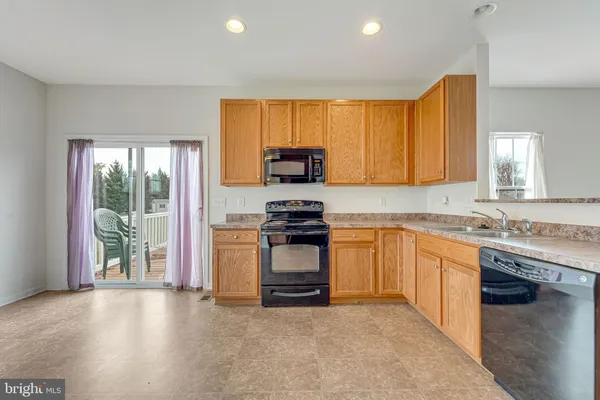 a kitchen with granite countertop a stove a sink and a refrigerator