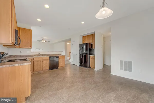 a view of a kitchen with a sink and dishwasher a refrigerator with wooden floor