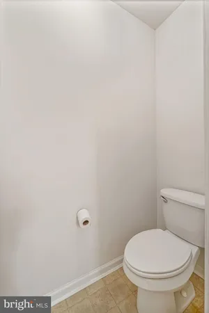 a white toilet sitting next to a white wall