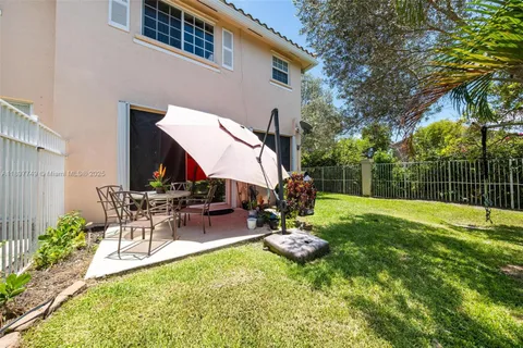 a view of backyard with wooden fence and large trees