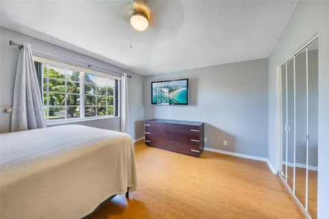 a spacious bedroom with a bed and a dresser next to a window