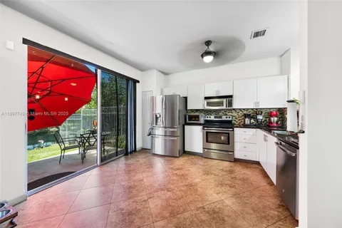 a kitchen with granite countertop a stove a refrigerator and a sink