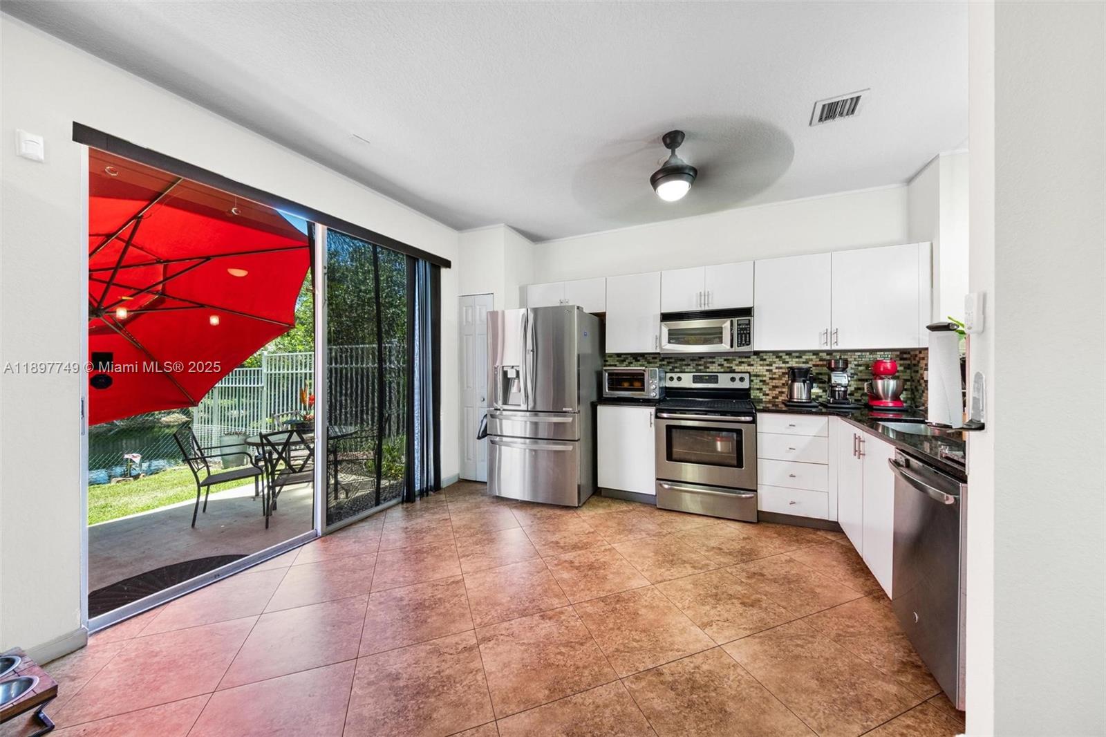 3869 Northwest 92nd Avenue Sunrise, FL 33351 - Photo 3 of 40 a kitchen with granite countertop a stove a refrigerator and a sink