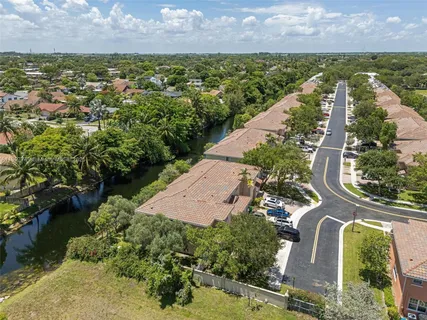 an aerial view of residential houses with outdoor space and trees