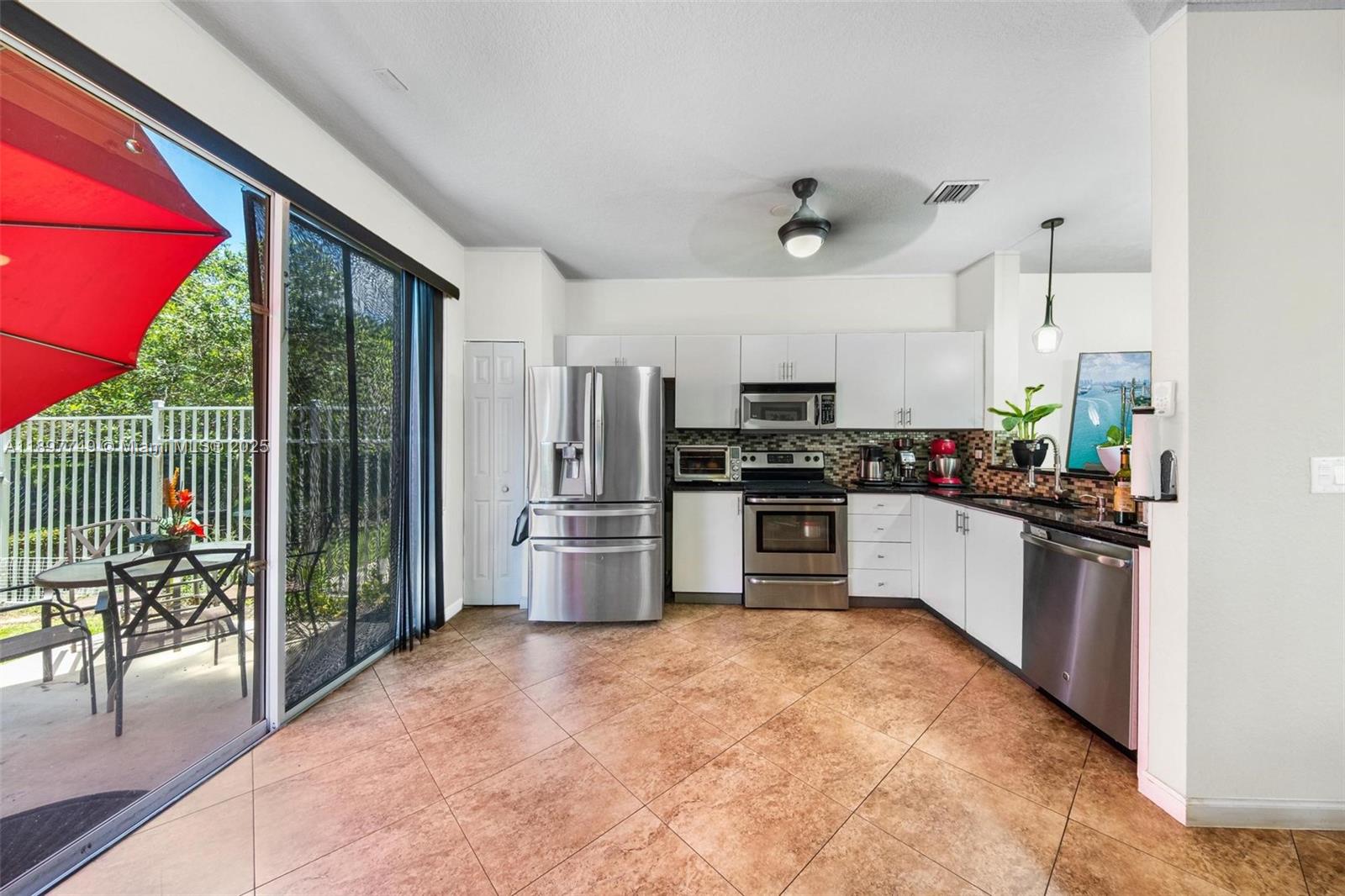 3869 Northwest 92nd Avenue Sunrise, FL 33351 - Photo 4 of 40 a kitchen with refrigerator and chairs