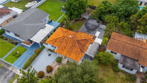 an aerial view of a house with outdoor space and swimming pool
