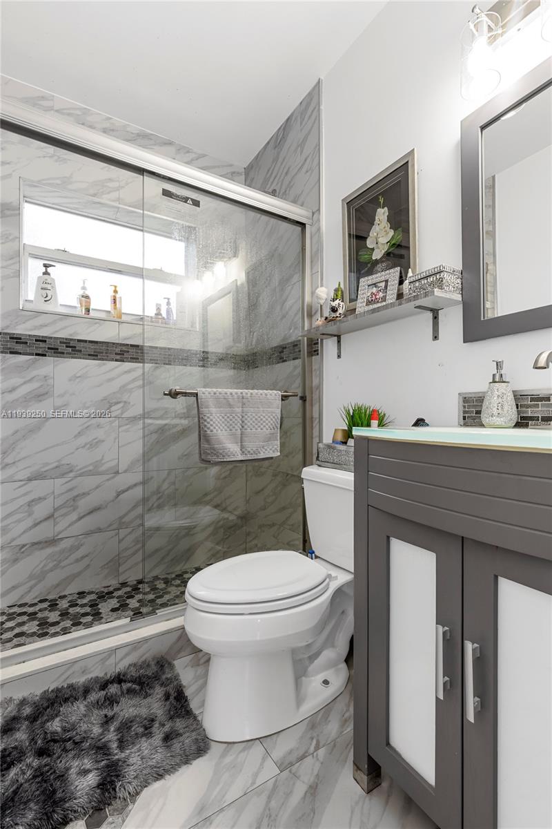 116 East 59th Street Hialeah, FL 33013 - Photo 32 of 51 a bathroom with a toilet a sink and mirror