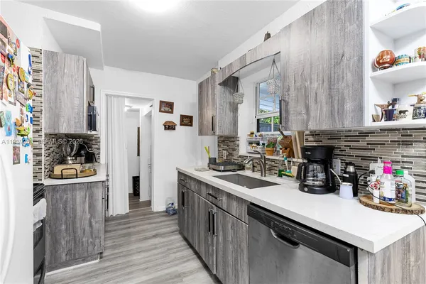 a kitchen that has a lot of cabinets a sink and appliances in it