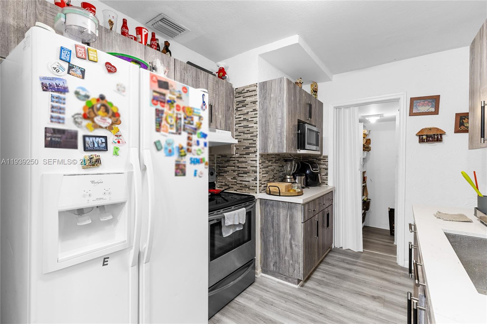 116 East 59th Street Hialeah, FL 33013 - Photo 37 of 51 a kitchen with stainless steel appliances a stove a refrigerator and a wooden floor