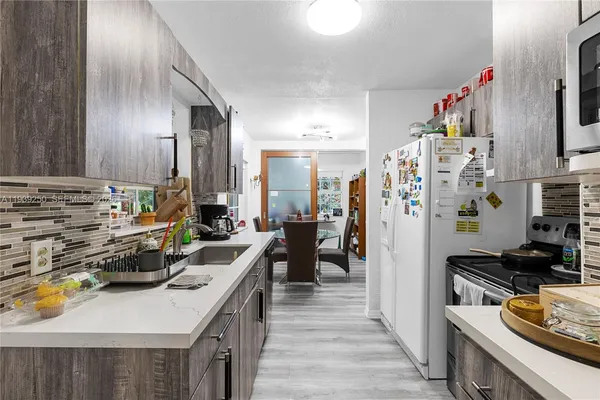 a kitchen with a refrigerator and a stove top oven