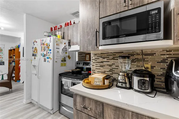 a view of a refrigerator in kitchen and wooden floor