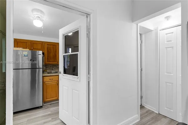 a kitchen with stainless steel appliances granite countertop a refrigerator a sink and white cabinets