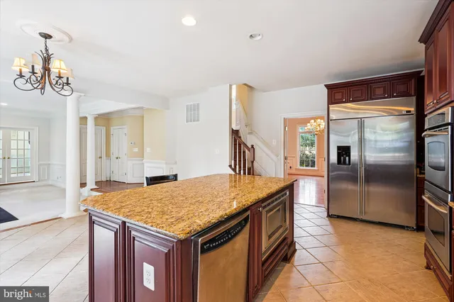 a dining room with wooden floor a chandelier a glass table and chairs