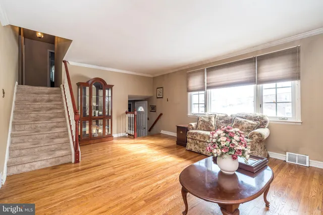 a living room with furniture chandelier and wooden floor