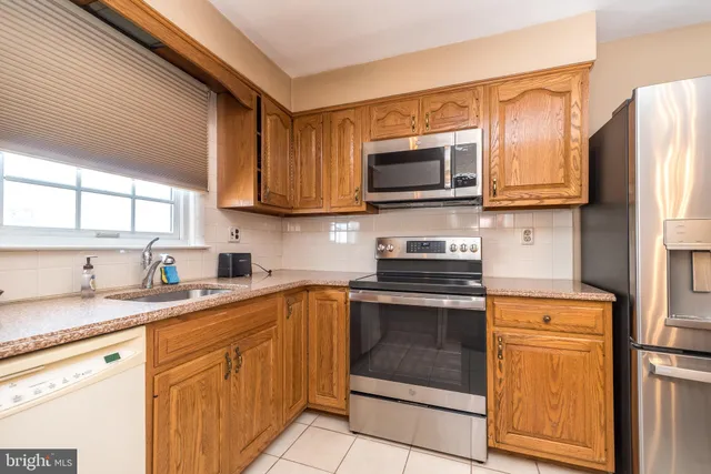 a kitchen with stainless steel appliances granite countertop a stove sink microwave and refrigerator