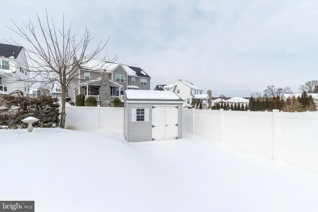 a view of a white house with a yard and covered with snow