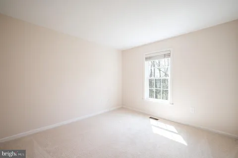 a view of an empty room with a fireplace and a window