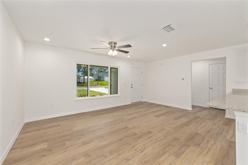 13031 Northeast 7th Loop Silver Springs, FL 34488 - Photo 12 of 34 wooden floor in an empty room with a window