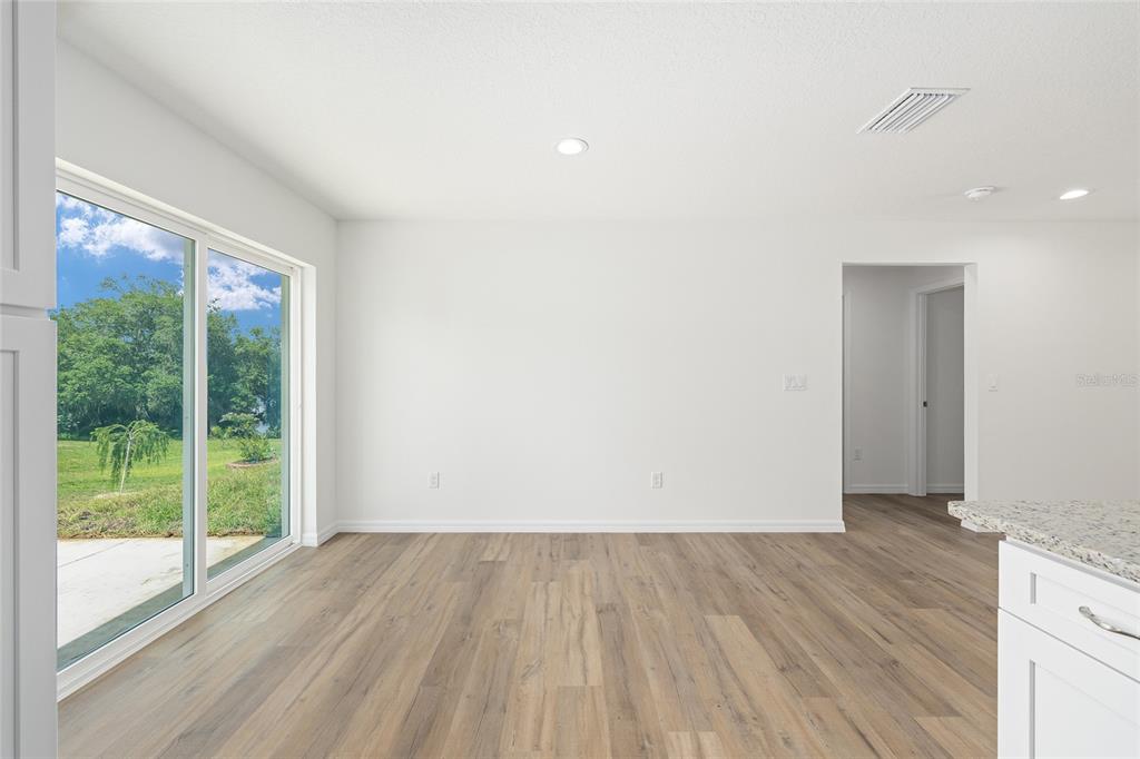 13031 Northeast 7th Loop Silver Springs, FL 34488 - Photo 14 of 34 a view of an empty room with wooden floor and a window