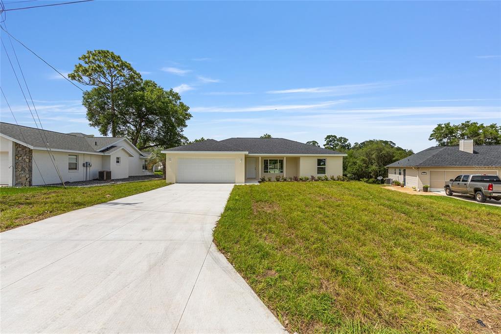 13031 Northeast 7th Loop Silver Springs, FL 34488 - Photo 3 of 34 a front view of a house with a yard and trees