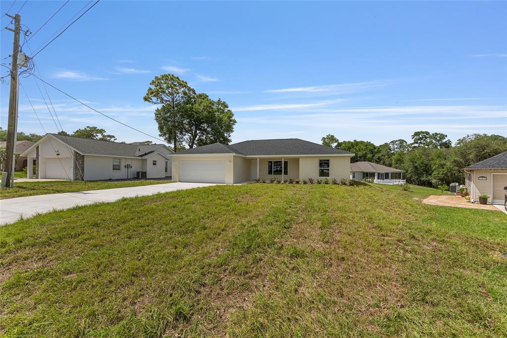 13031 Northeast 7th Loop Silver Springs, FL 34488 - Photo 4 of 34 a front view of a house with a garden