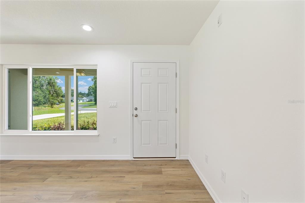 13031 Northeast 7th Loop Silver Springs, FL 34488 - Photo 8 of 34 an empty room with wooden floor and windows
