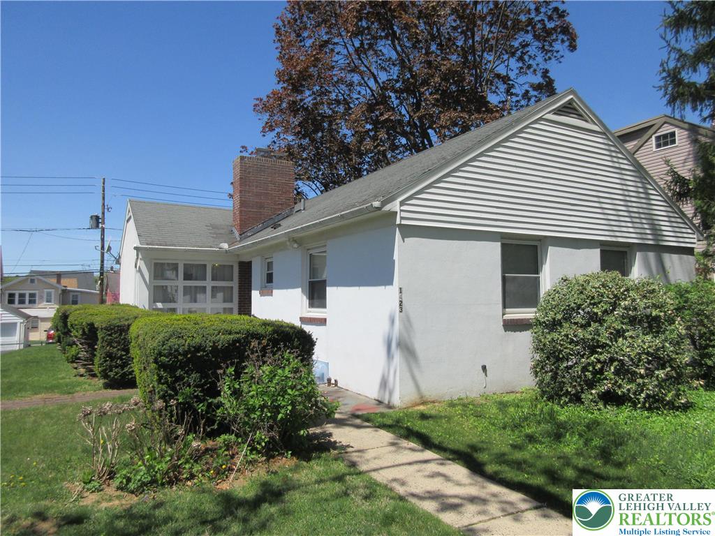 1423 Maple Street Bethlehem, PA 18018 - Photo 1 of 1 Mature hedges frame a concrete pathway leading alongside the stucco exterior.