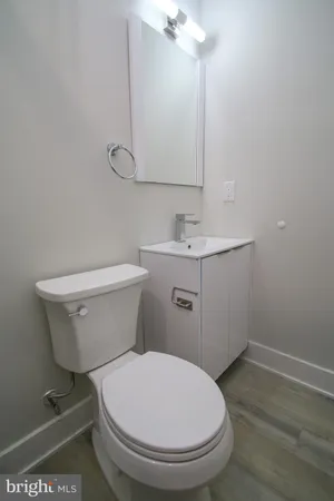 a bathroom with a toilet a sink and mirror