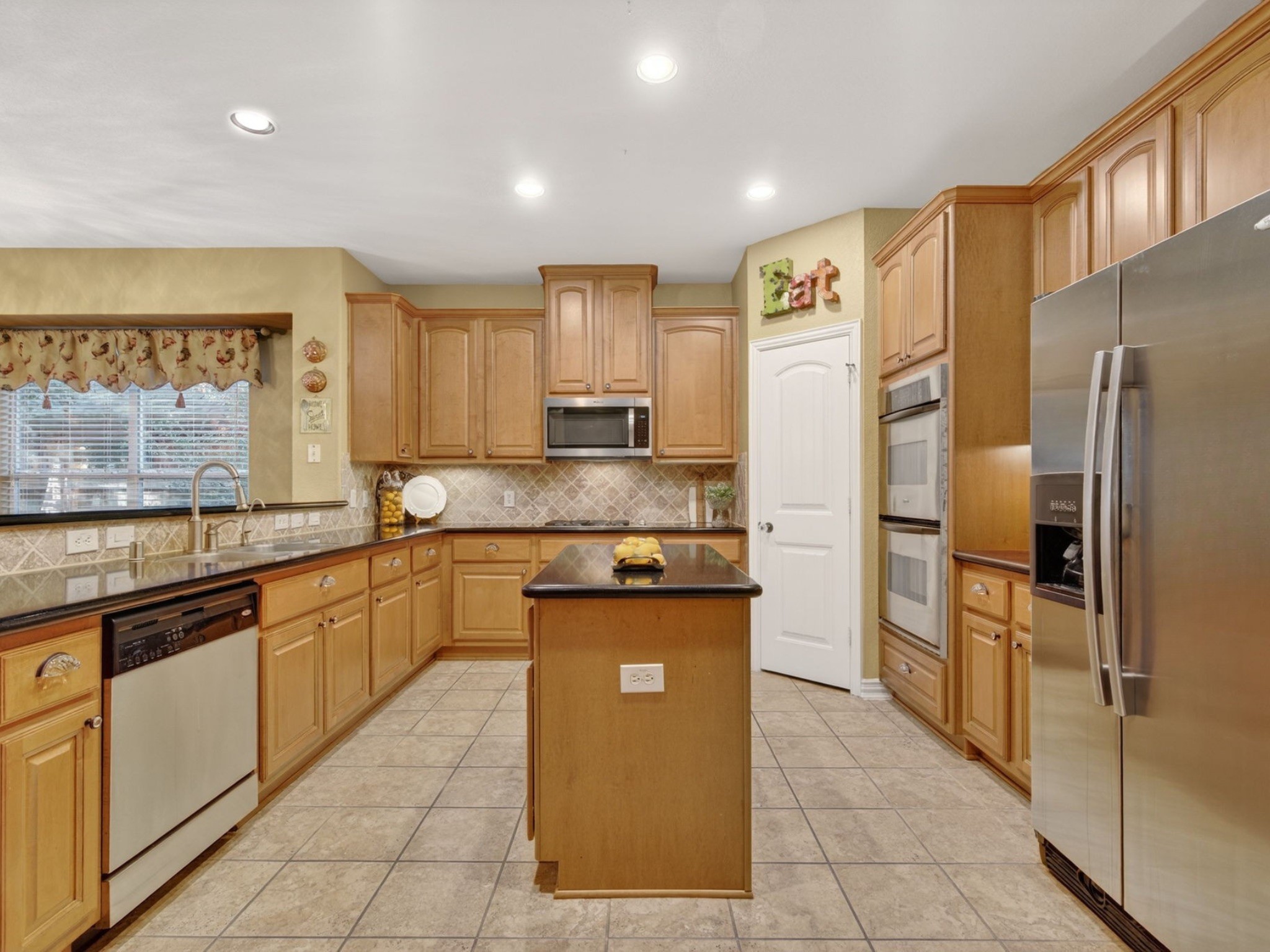 194 Maple Grove Drive Conroe, TX 77384 - Photo 6 of 25 a kitchen with granite countertop a refrigerator and a stove top oven
