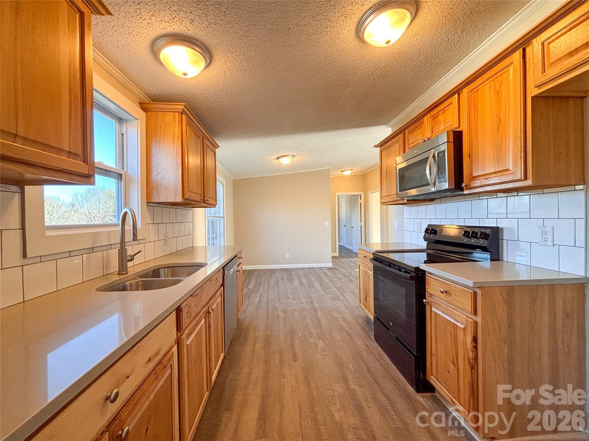 3596 Gull Street Hudson, NC 28638 - Photo 12 of 23 a kitchen with stainless steel appliances granite countertop a sink stove and wooden cabinets