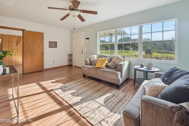 a living room with furniture and a floor to ceiling window