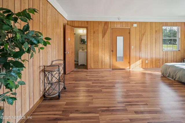 a view of a room with wooden floor and a potted plant