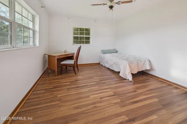 a bedroom with a bed and wooden floor