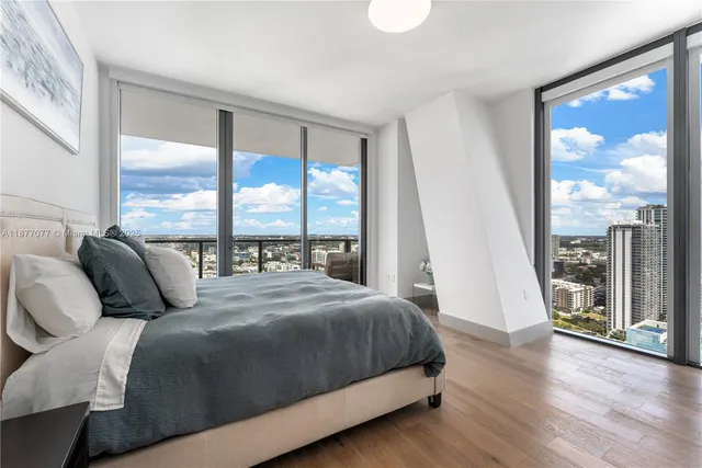 a bedroom with a large window and a bed
